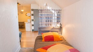 A narrow room with a bed, a desk, and a window with a view. - Homerez - Apartment in Lourdes (Lourdes)