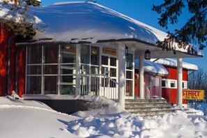 A building with a covered entrance, large windows, and a sign that reads "Start Ski War". - Ylläs Lake hotel (Kolari)