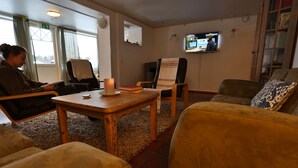 A cozy living room with a fireplace, a television, and comfortable seating. - Ylläs Lake hotel (Kolari)