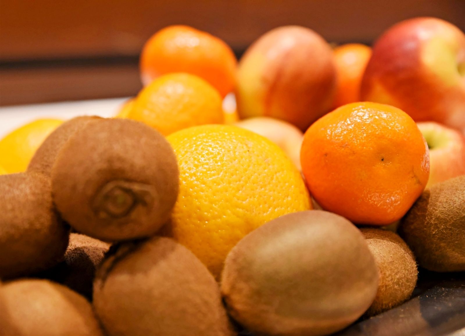A variety of fruits including oranges, kiwis, and apples.