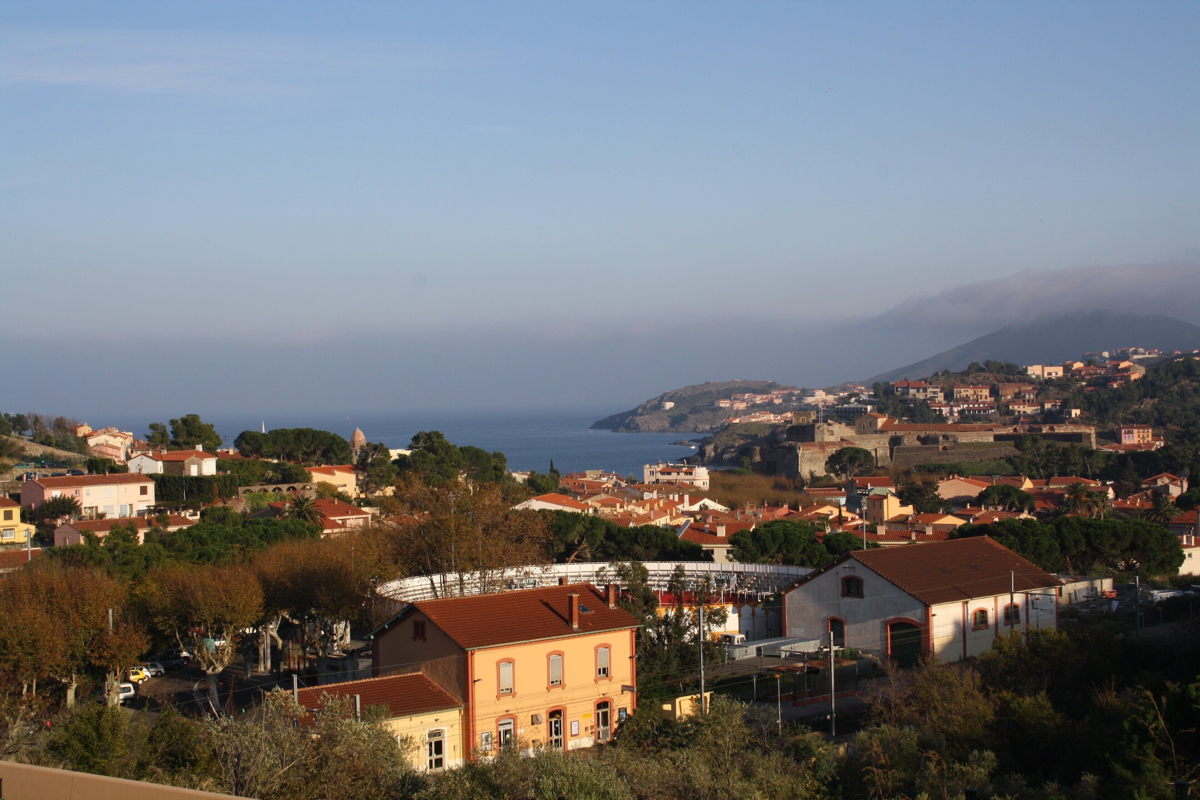 A coastal town with historic buildings, a prominent church, and a view of the sea.