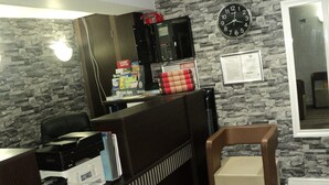 A reception desk with a clock, a 'No Smoking' sign, and a 'Visit Tips' brochure. - New Globe Hotel (London)