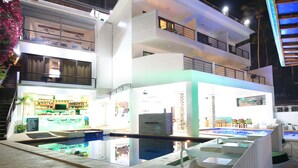Un hôtel moderne doté d’une piscine, d’un espace extérieur aménagé et d’un bar.
