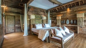 Una habitación rústica de madera con una cama, un banco y una pared decorada con objetos con forma de pájaros.