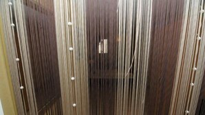 A vertical wooden panel with evenly spaced, round, white fixtures. - Hotel Hirsch (Fulda)