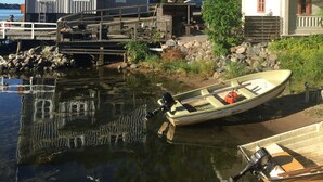 A waterfront property with a dock, a small boat, and a house with a red roof. - Hostel Lotsen (Dalaro)