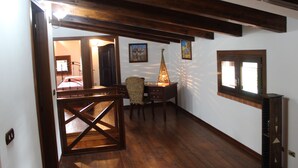 A room with wooden beams, a desk with a lamp, and a bed in the background. - Villa Delle Ninfee (Mazara del Vallo)