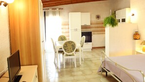 Una cocina compacta con comedor, una cama y un televisor.