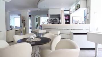 A modern kitchen with a central island, white cabinetry, and a dining area with a round table and chairs.
