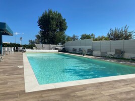 Piscina all'aperto, una piscina con cascata, lettini