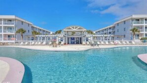 A hotel with a central pool, multiple balconies, and a covered entrance. - Time to get… 🎶 Knee deep in the water somewhere! 🎶 on island time! (Gulf Shores)