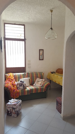 Une pièce confortable avec un canapé, une petite table et un lit.
