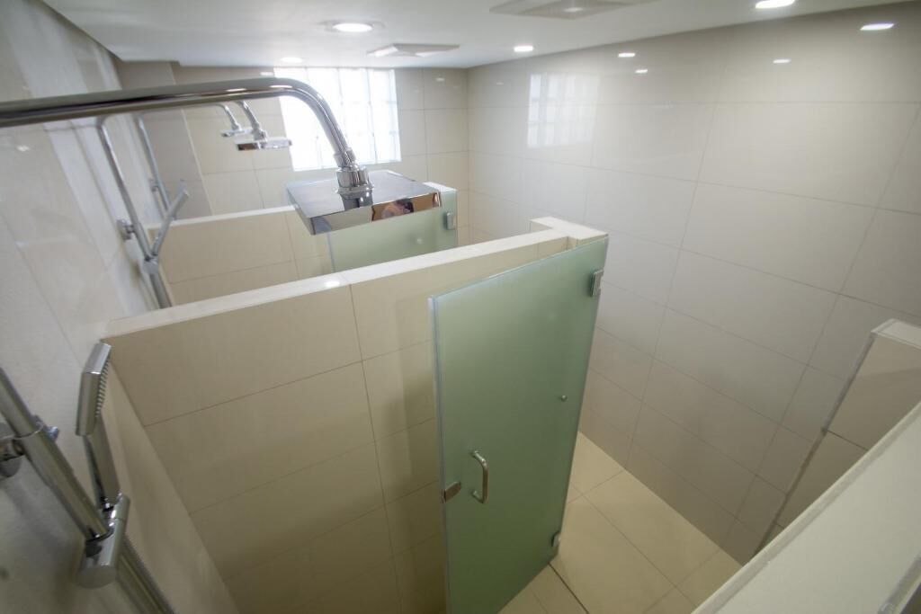 Un baño con ducha, lavamanos y retrete.