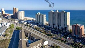 Un paisaje urbano costero con rascacielos, una carretera y una playa.
