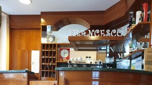 Un coin cuisine avec des placards en bois, une machine à café et une horloge au mur.