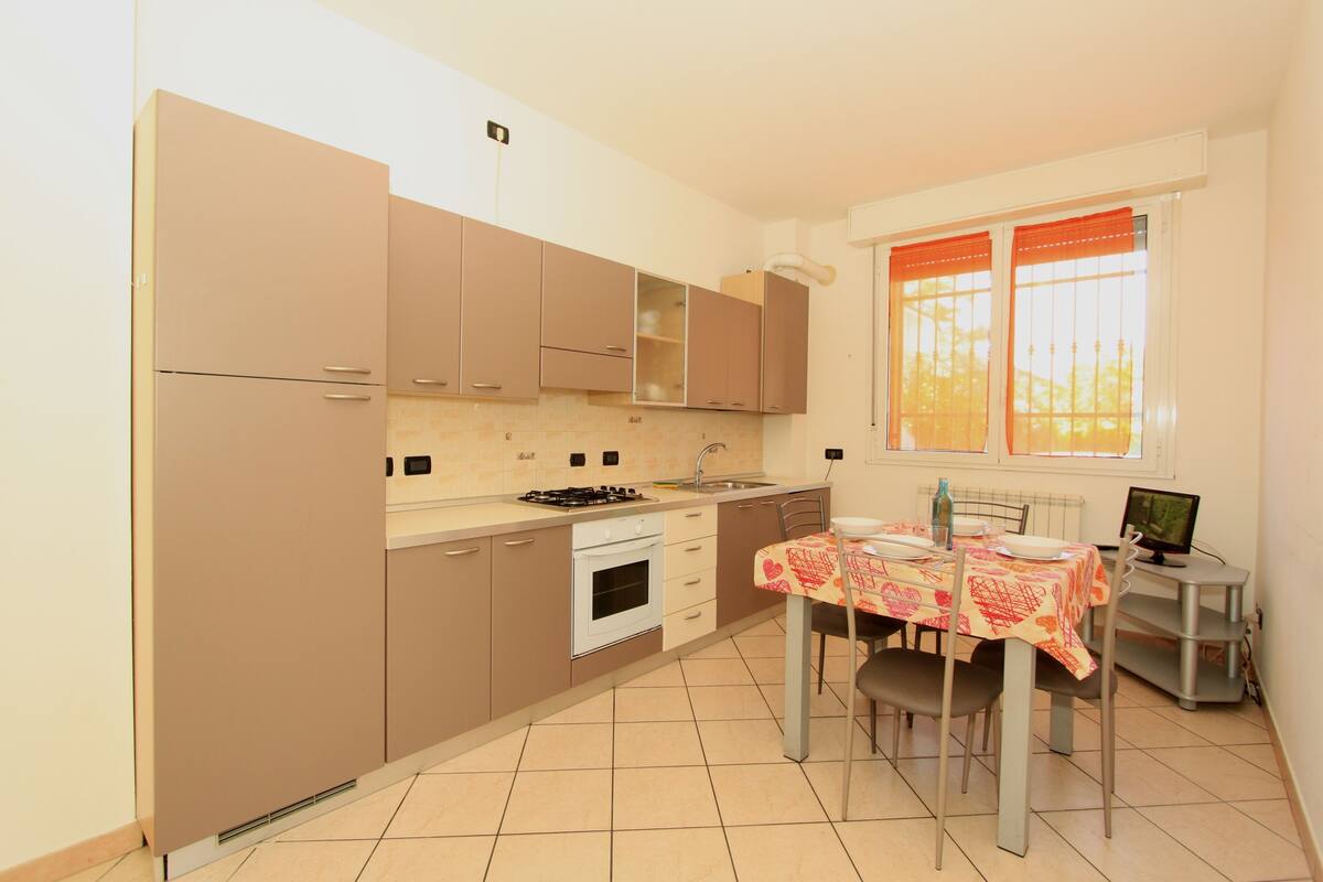Una cocina compacta con comedor, que incluye estufa, horno y una mesa de comedor para dos.
