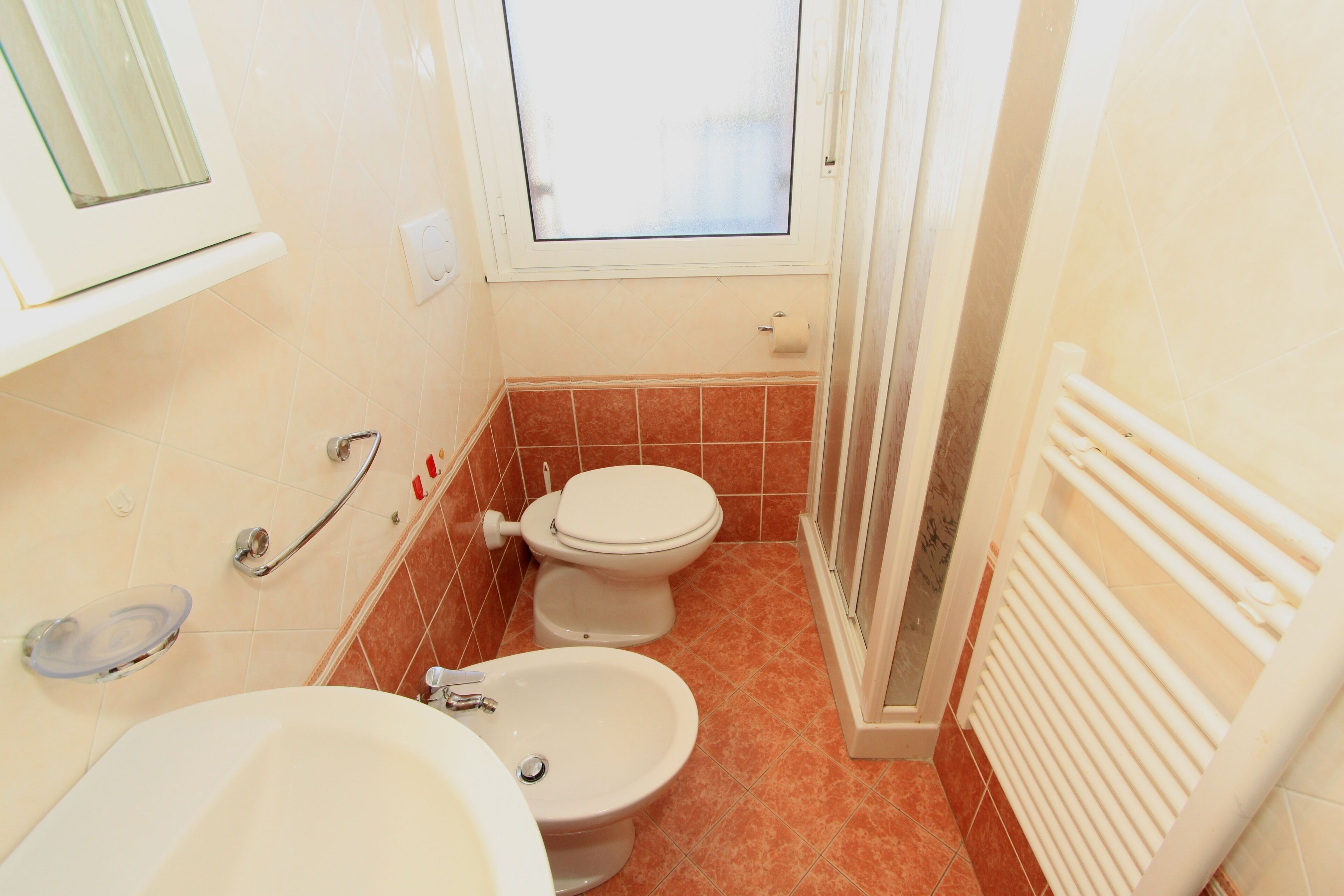 A bathroom with a toilet, bidet, and sink.