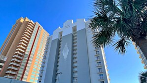 Un grand hôtel avec un logo bien visible, de nombreux balcons et un parking souterrain.