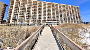 A high-rise hotel with multiple balconies, a covered walkway, and a view of the surrounding area. - Relax and Catch a couple of fish! 🎣 ~ There is something for everyone! (Orange Beach)