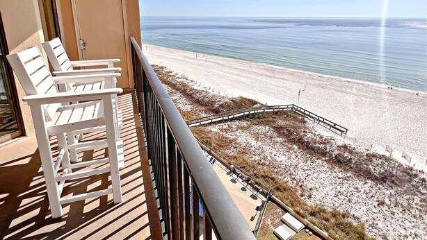 A balcony with white chairs, a view of the beach, and a clear sky. - Relax and Catch a couple of fish! 🎣 ~ There is something for everyone! (Orange Beach)