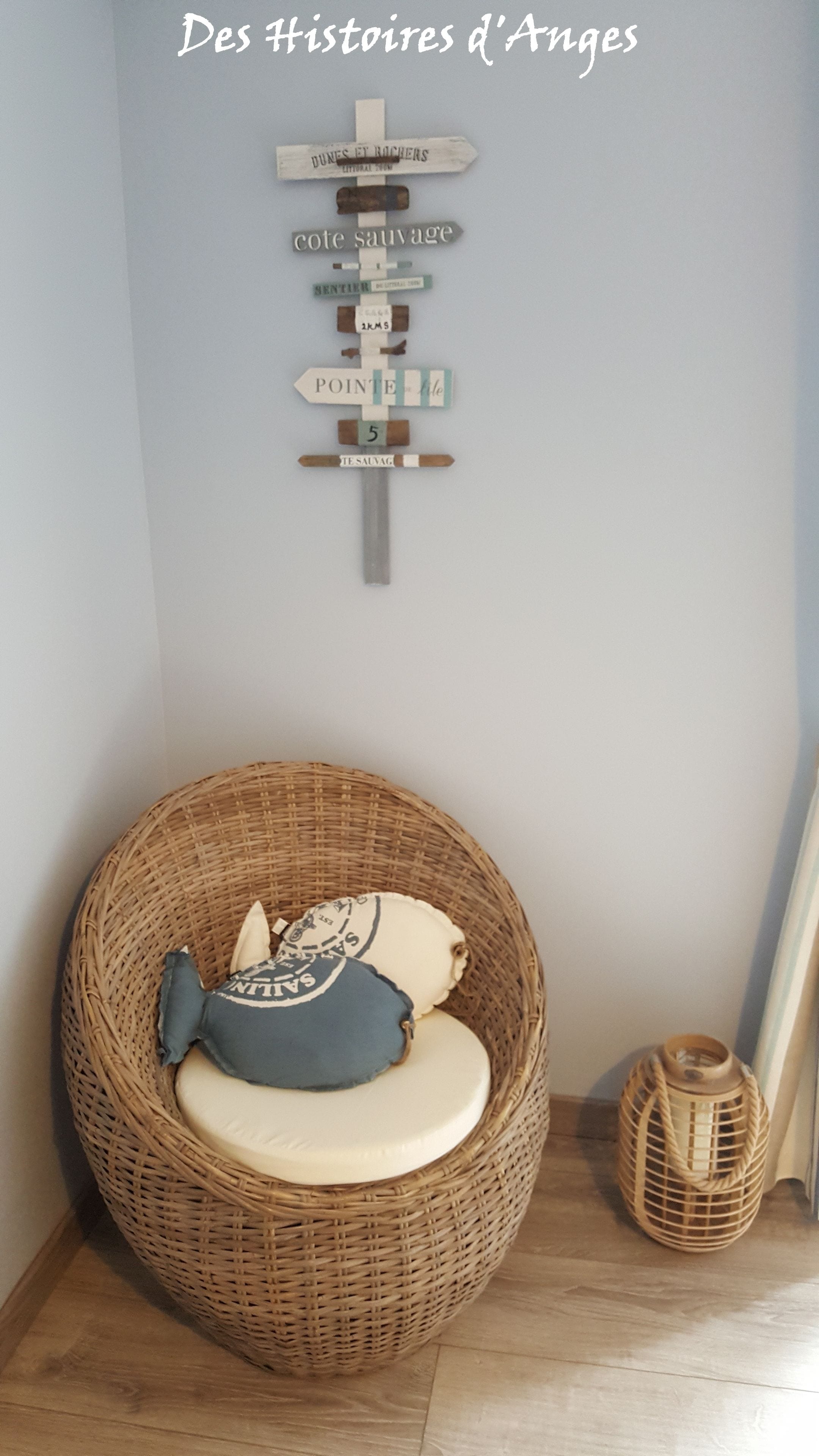 A corner with a wicker chair, a small basket, and a wall-mounted sign with directional text.