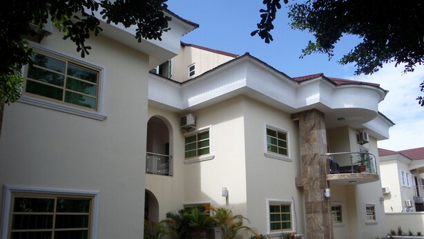 A multi-story building with a flat roof, large windows, and a paved courtyard. - Nordic Hospitality Hotel (Abuja)