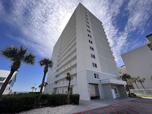 Un grand hôtel moderne, doté de nombreux étages et de balcons, situé près d’une plage.