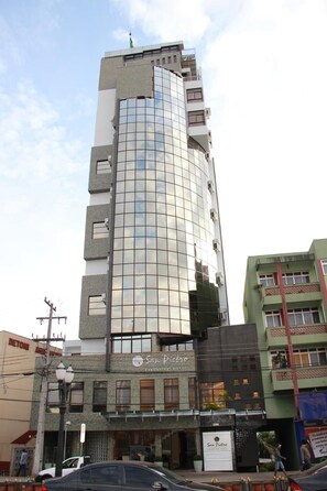 A high-rise building with a reflective glass facade, multiple balconies, and a sign for 'San Pietro Executive Hotel' at the base. - Hotel San Pietro (Pato Branco)