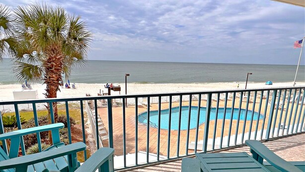 A poolside area with a view of the beach and ocean.