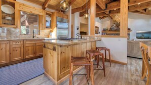 Una cocina amplia con armarios de madera, una isla grande y taburetes de bar.