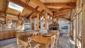 Una cocina amplia con vigas de madera, una isla grande y un comedor con sillas de madera.