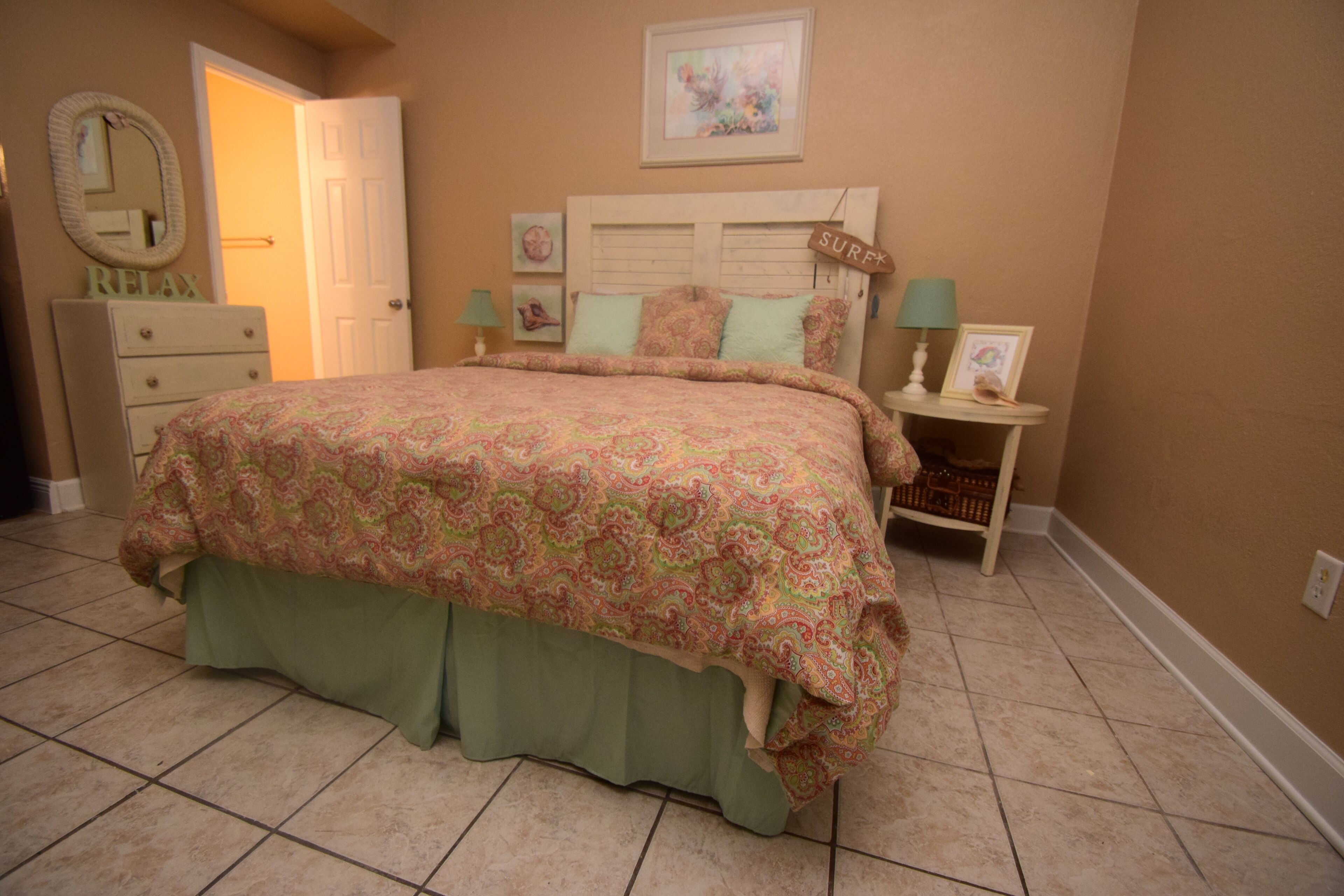 Un dormitorio con cama, cómoda y mesitas de noche.
