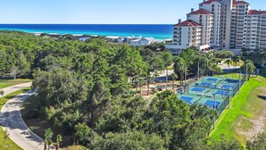 A resort with a tennis court, lush greenery, and a view of the ocean. - ⭐Gulf Views | Walk2Beach | Balcony | 2BR Summit at Tops'l 714⭐ (Miramar Beach)