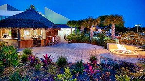 A resort with a thatched-roof structure, a fire pit, and tropical landscaping. - ⭐Gulf Views | Walk2Beach | Balcony | 2BR Summit at Tops'l 714⭐ (Miramar Beach)