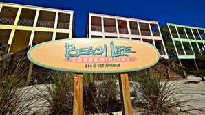 A sign for Beach Life Condominiums at 314 E 1st Avenue. - Waves, Sand, and Fun in the Sun come join us for a great time. 🌞🍂 (Gulf Shores)