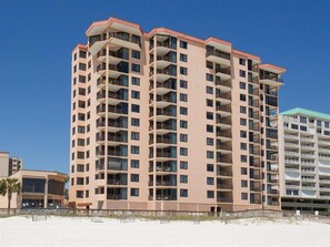 Un hôtel à plusieurs étages doté de balcons, situé près d’une plage.