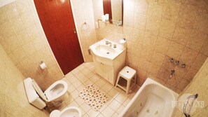 A bathroom with a toilet, sink, and bathtub. - Edymar (Puerto Madryn)