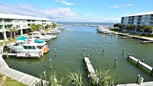 Un port de plaisance avec des bateaux amarrés, un quai et un bâtiment doté de balcons.