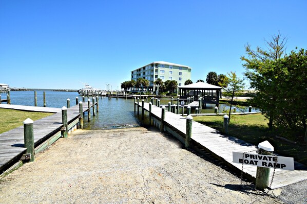 A private boat ramp leading to a marina with a building and a gazebo in the background.