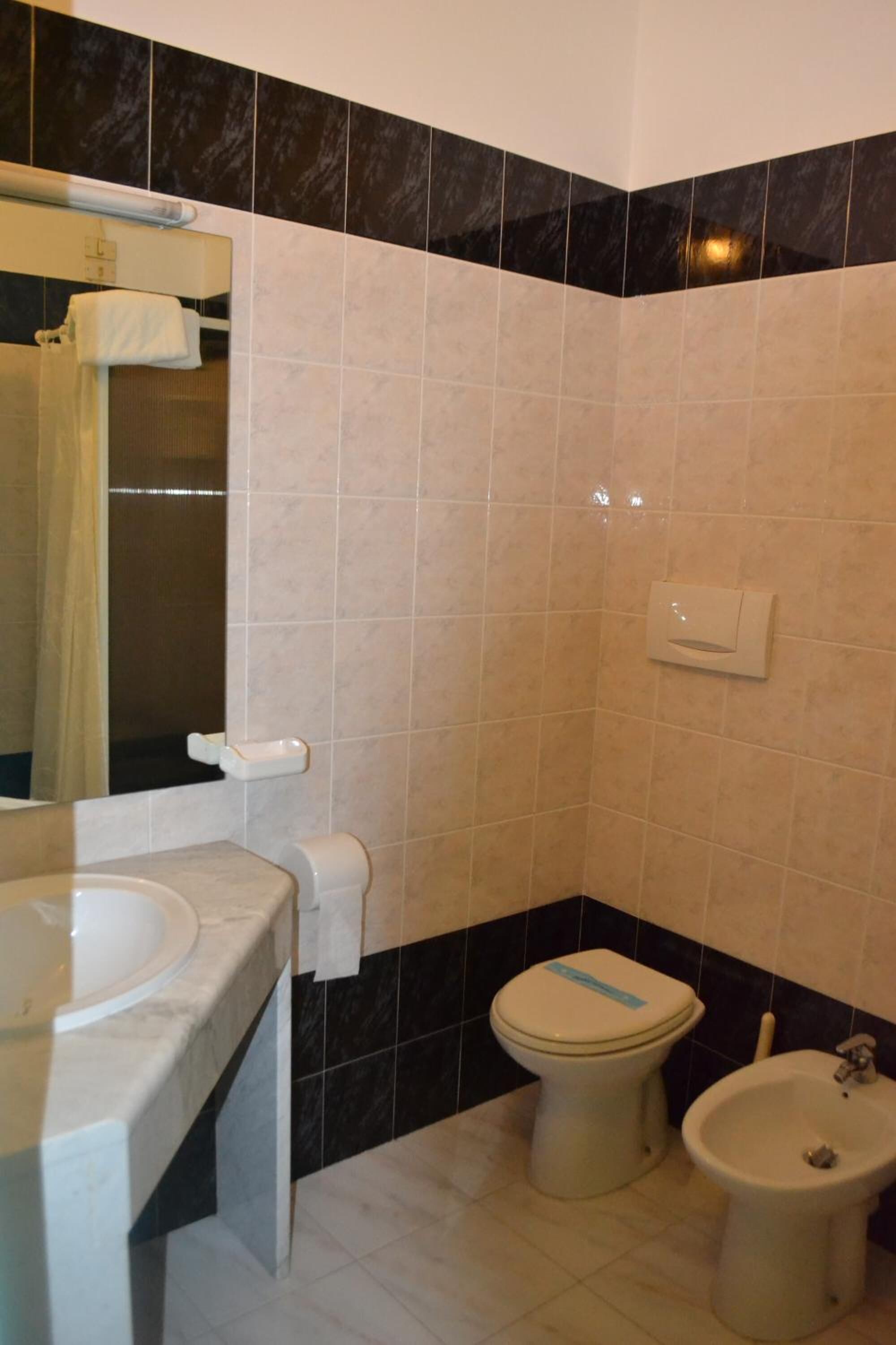 A bathroom with a toilet, bidet, and sink.