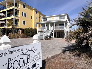 A two-story building with a balcony and a sign for 'Sun Dreams II' in front.