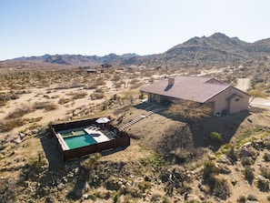 Una casa con piscina, rodeada por un paisaje desértico y montañas.