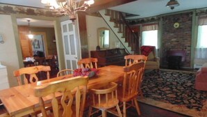 A dining area with a wooden table and chairs, a chandelier, and a staircase leading to another room. - 70 Private Acres-SKI! SKI! SKI! (Athol)