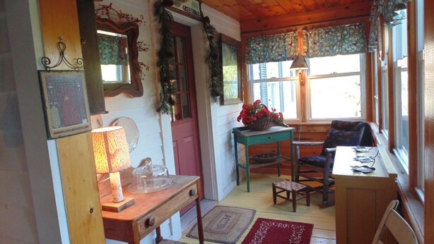 A cozy room with a wooden table, a chair, a lamp, and a window with curtains. - 70 Private Acres-SKI! SKI! SKI! (Athol)