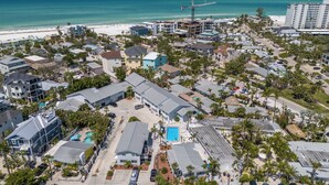 An aerial view of a coastal residential area with multiple buildings, a beach, and a clear blue sky. - Perfect Local In Village,1 1/2 Block From #1 Beach In USA, Pool, Wifi, Sun & Fun (Siesta Key)