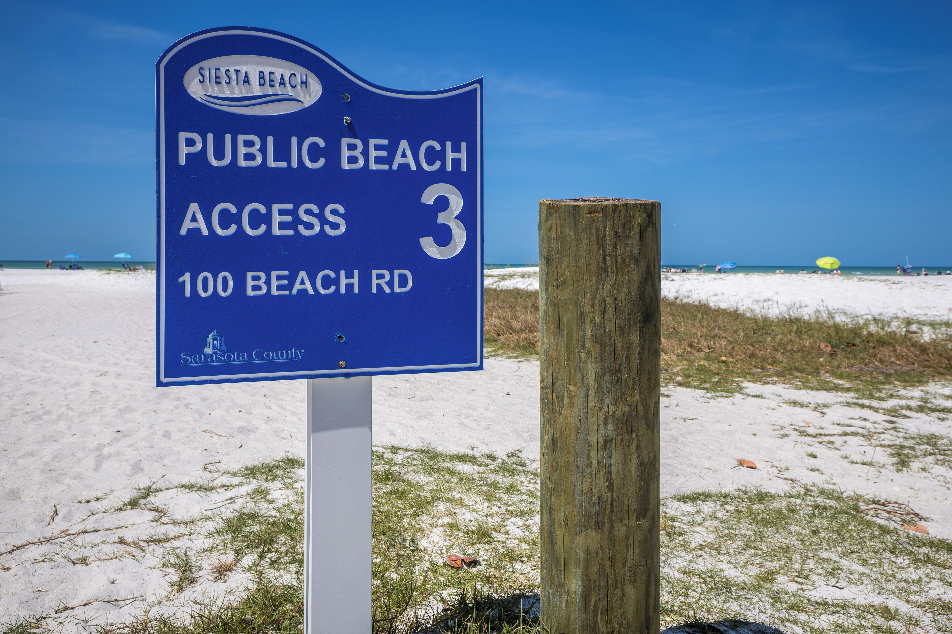 Señal azul que indica acceso público a la playa Siesta, en 100 Beach Rd, Condado de Sarasota.