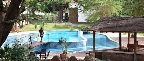 Una piscina al aire libre, sillones reclinables de piscina