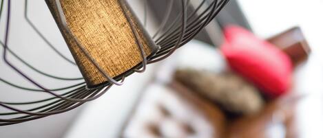 Een detail van een metalen stoel met een houten rugleuning en een rode kussen.