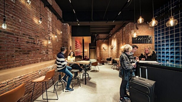 A modern cafe with brick walls, hanging pendant lights, and a counter area. - Habitat Apartments Hot Jazz (Barcelona)