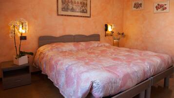 A bedroom with a bed, nightstands, a wall-mounted phone, and a framed picture.